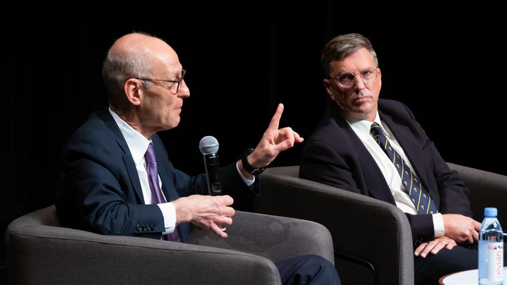 Two men on a panel. The man on the right is Julian Savulescu