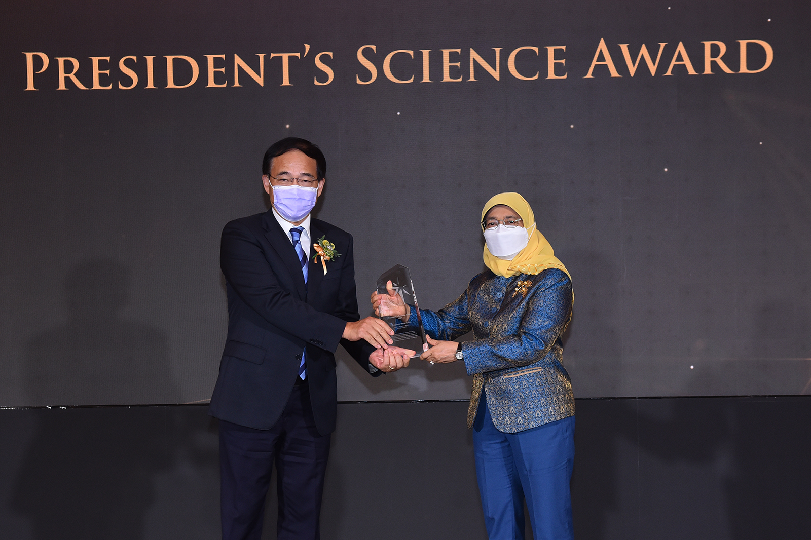 Wang Linfa accepts the Science Medal from President Madam Halimah Yacob